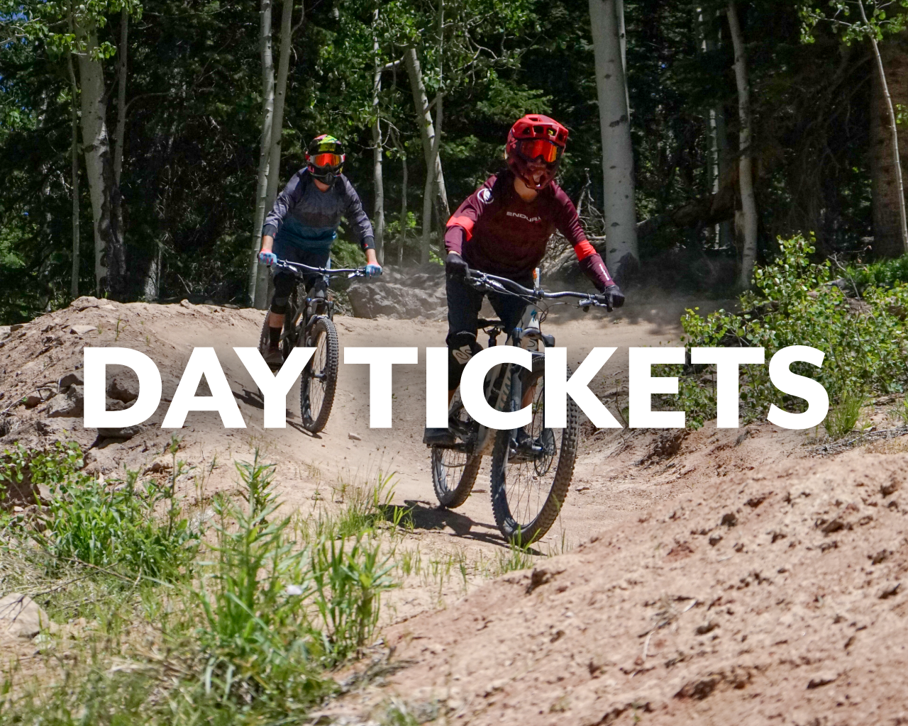 Day Tickets button, mountain bikers on trail at Powderhorn Mountain Resort
