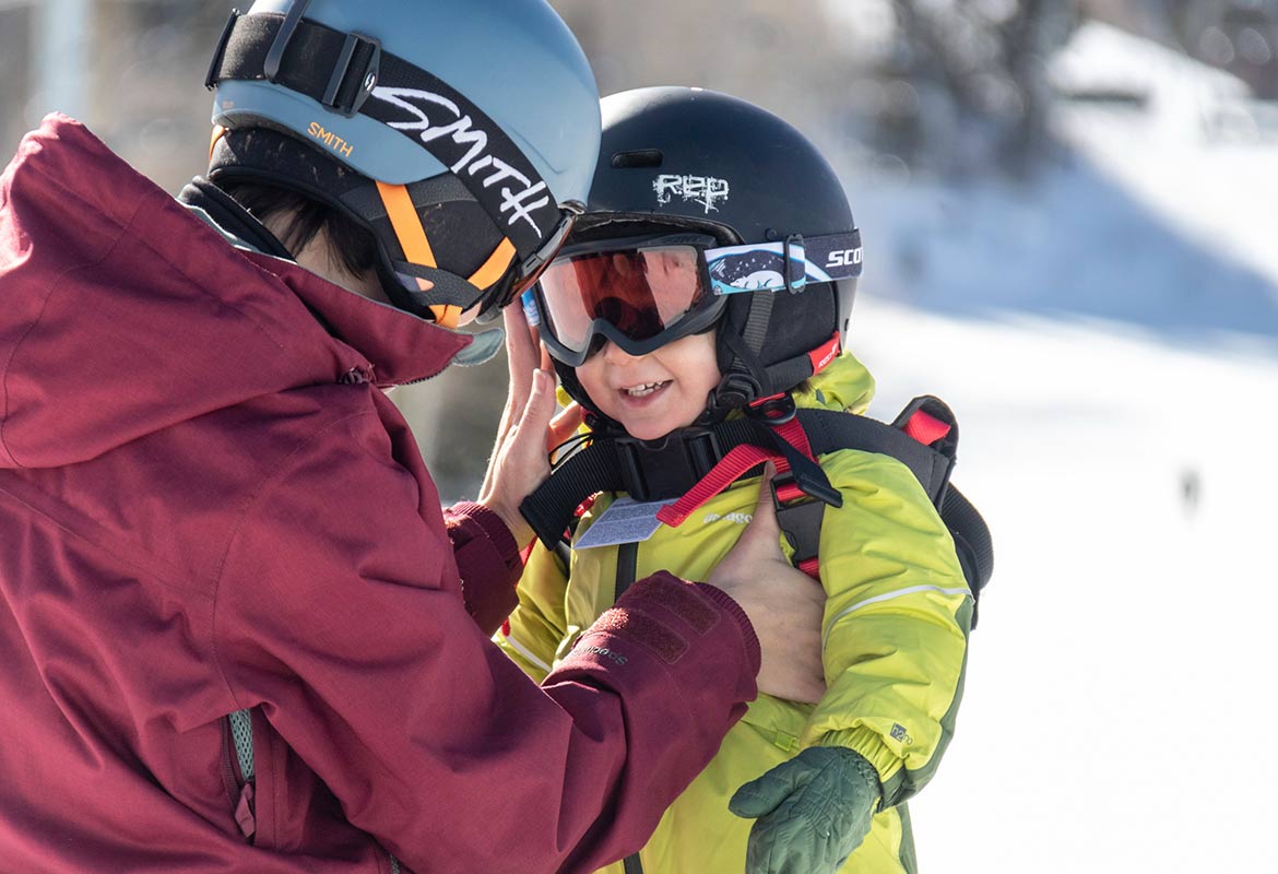 A parent and toddler on the snow at Powderhorn